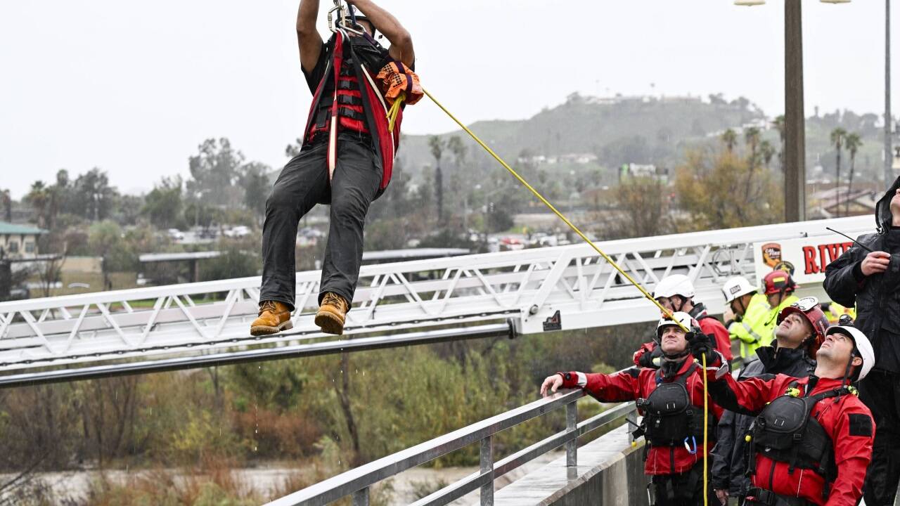 Einsatzkräfte der Riverside County und City Firefigthers bergen Personen, die auf einer kleinen Insel im Santa Ana River gestrandet waren.  