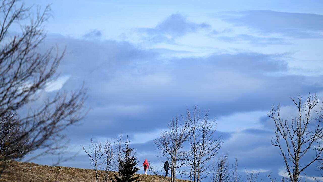 Zwei Personen wandern bei Sonnenschein auf dem Grat des Gaisberges in Salzburg. 
