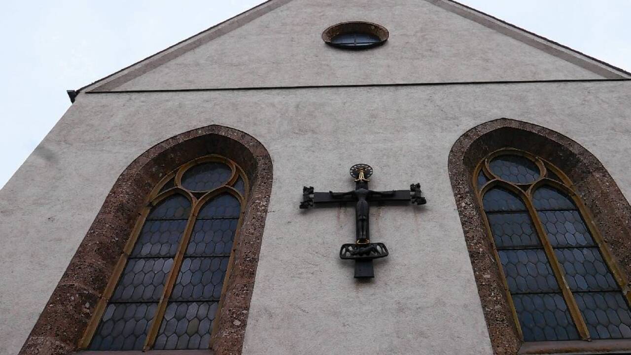 Das Kreuz an der Kirchenfassade von St. Andrä in Salzburg.  