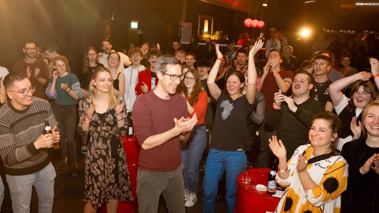 KPÖ-plus-Wahlgewinner Kay-Michael Dankl jubelt mit Mitstreitern und Mitstreiterinnen.  