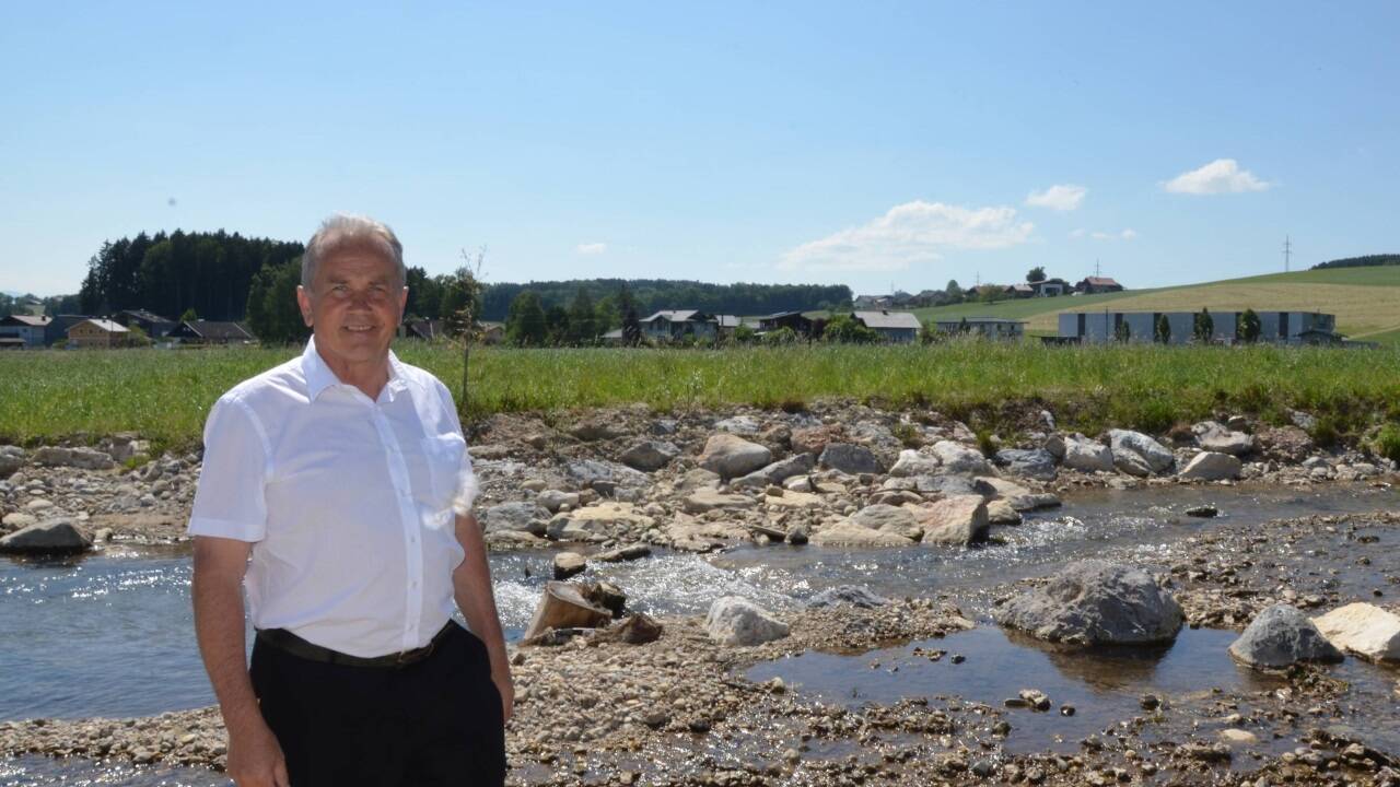 Der Köstendorfer Bürgermeister Wolfgang Wagner im Sommer 2023 vor dem Eisbach und dem neuen Gewerbegebiet in Weng Der Köstendorfer Bürgermeister Wolfgang Wagner im Sommer 2023 vor dem Eisbach und dem neuen Gewerbegebiet in Weng