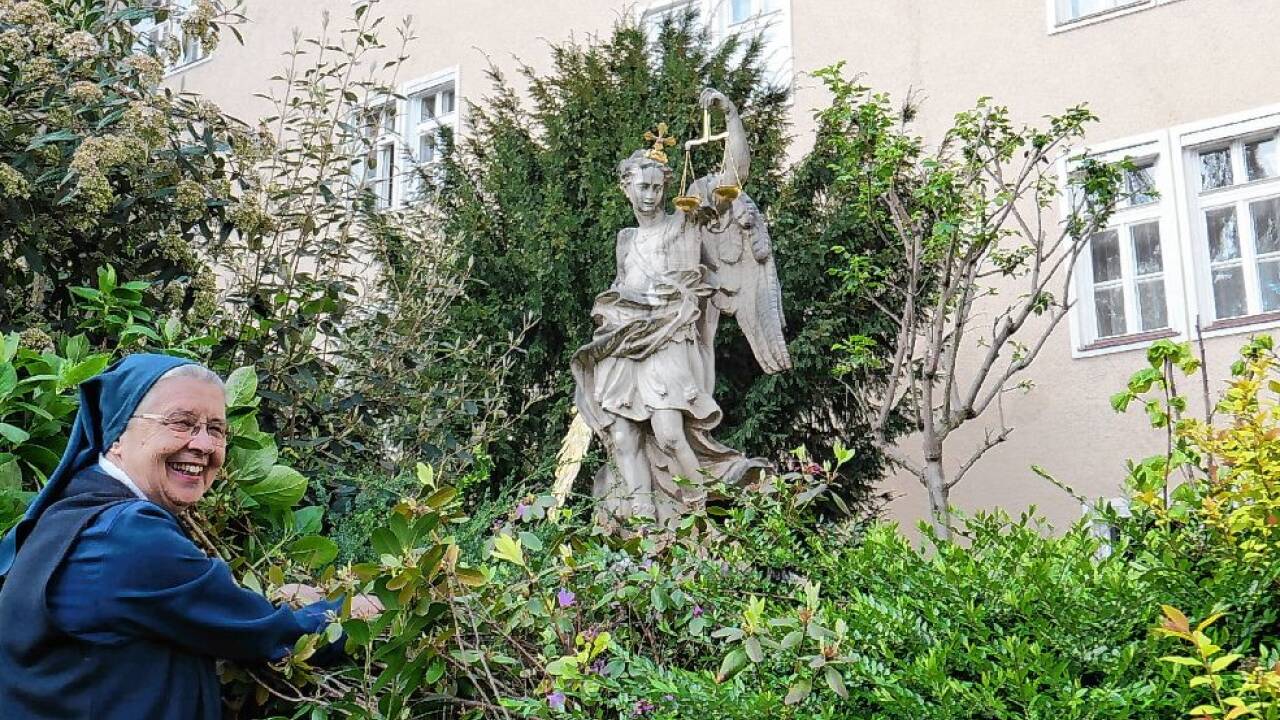 Schwesteroberin Brigitte Trattner versucht den Blick auf die Michaelsfigur für die Fotografin freizumachen.  