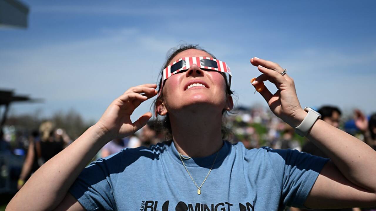 Menschen blicken gespannt gen Himmel 