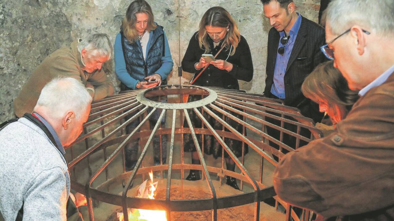 Mit einer brennenden Zeitung demonstriert Konrad Grundner die Tiefe des Brunnens in der Höhlenburg. 