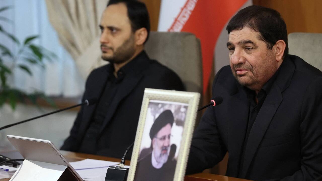 Irans Erster Vizepräsident Mohammad Mochber (2.v.l.), neben ihm der leere Sitz des verstorbenen Präsidenten Ebrahim Raisi (Porträt)  Irans Erster Vizepräsident Mohammad Mochber (2.v.l.), neben ihm der leere Sitz des verstorbenen Präsidenten Ebrahim Raisi (Porträt)