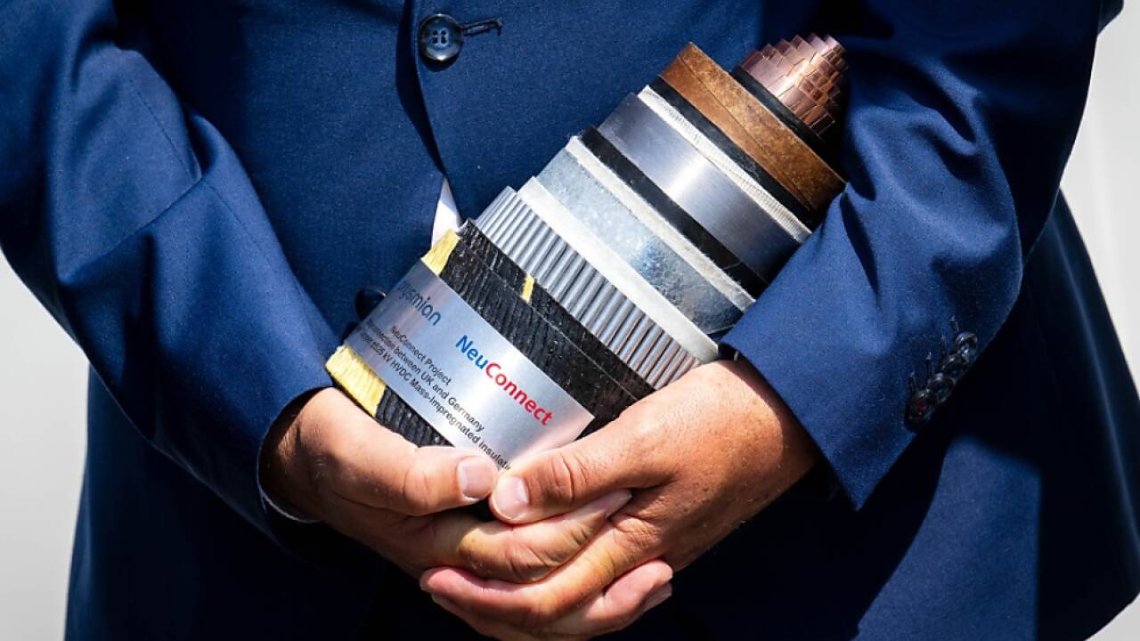 Robert Habeck mit einem Stück der neuen Stromleitung Neuconnect 