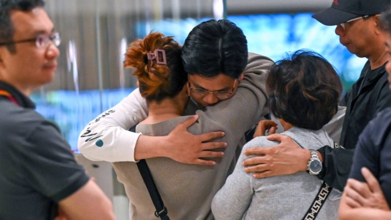 Passagiere am Airport in Singapur mit Angehörigen 
