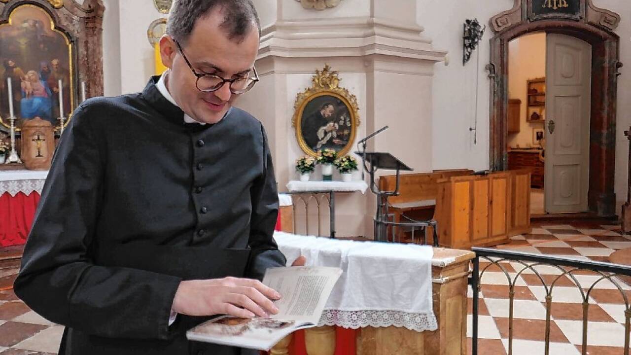 Pater Dieter Biffart liest ein paar Zeilen aus dem Kirchenführer vor.  