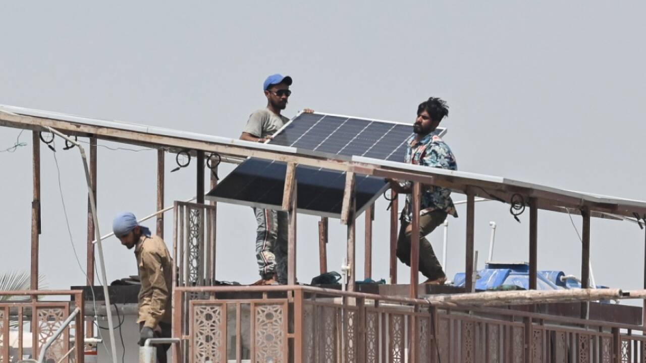 Arbeiter mit Solarpanelen an hei§em Tag in Karachi 