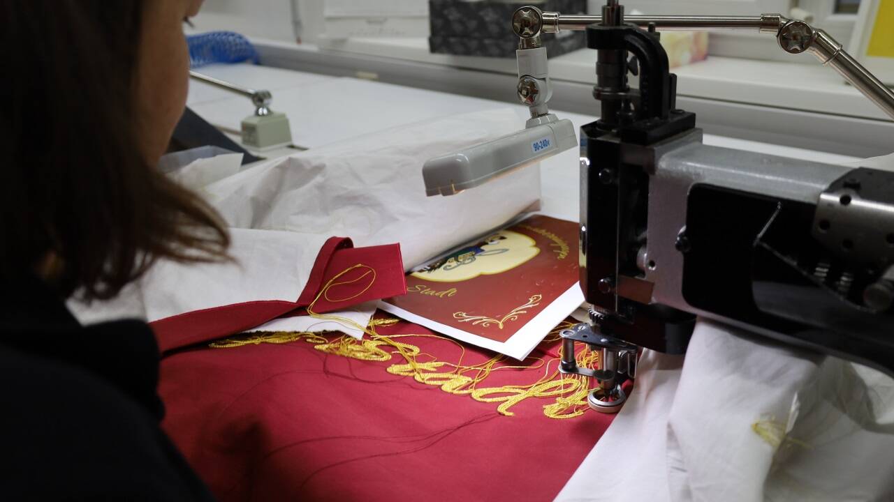 Die Fahne wurde bei Fahnengärtner in Mittersill gefertigt und bestickt. Im Bild das Sticken der Inschrift.  