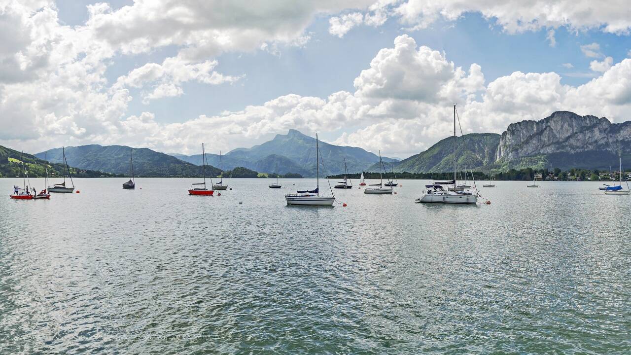 Blick auf den Mondsee mit der markanten Drachenwand und dem Schafberg im Hintergrund.  