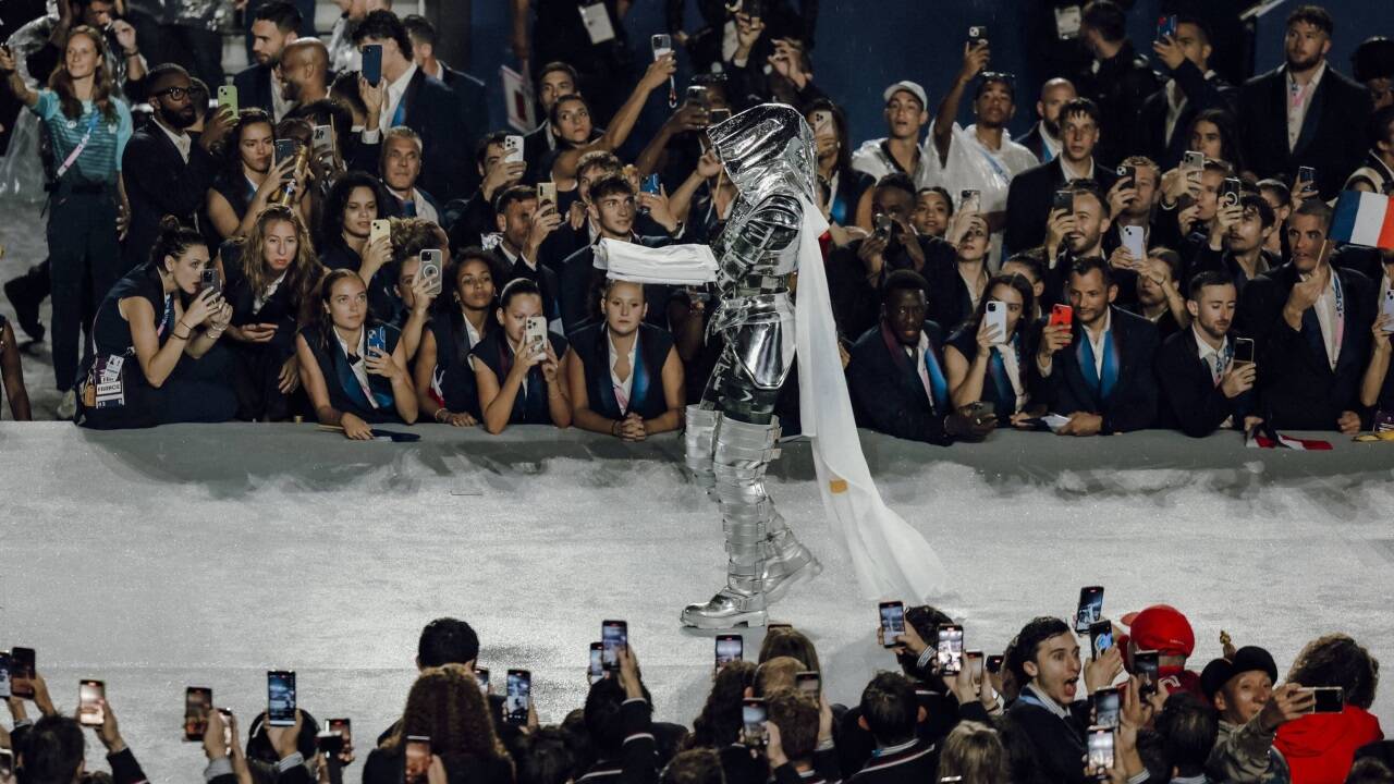 Trocadero schreitet mit der olympischen Flagge zur Bühne. 