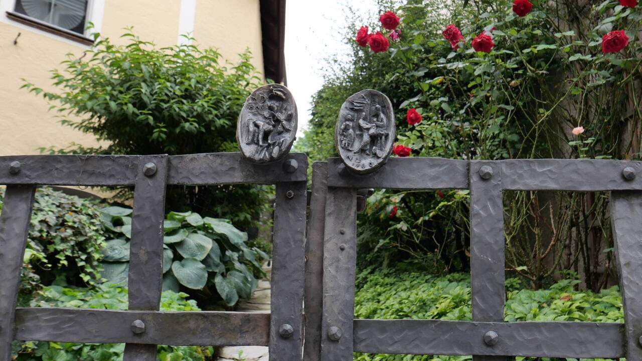 Ein künstlerisch gestaltetes Gartengitter fängt in Golling den Blick.  