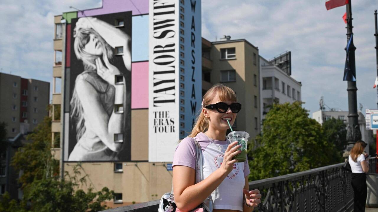 Symbolbild. Ein Swiftie posiert vor einem Taylor Swift Wandgemälde in Warschau. 