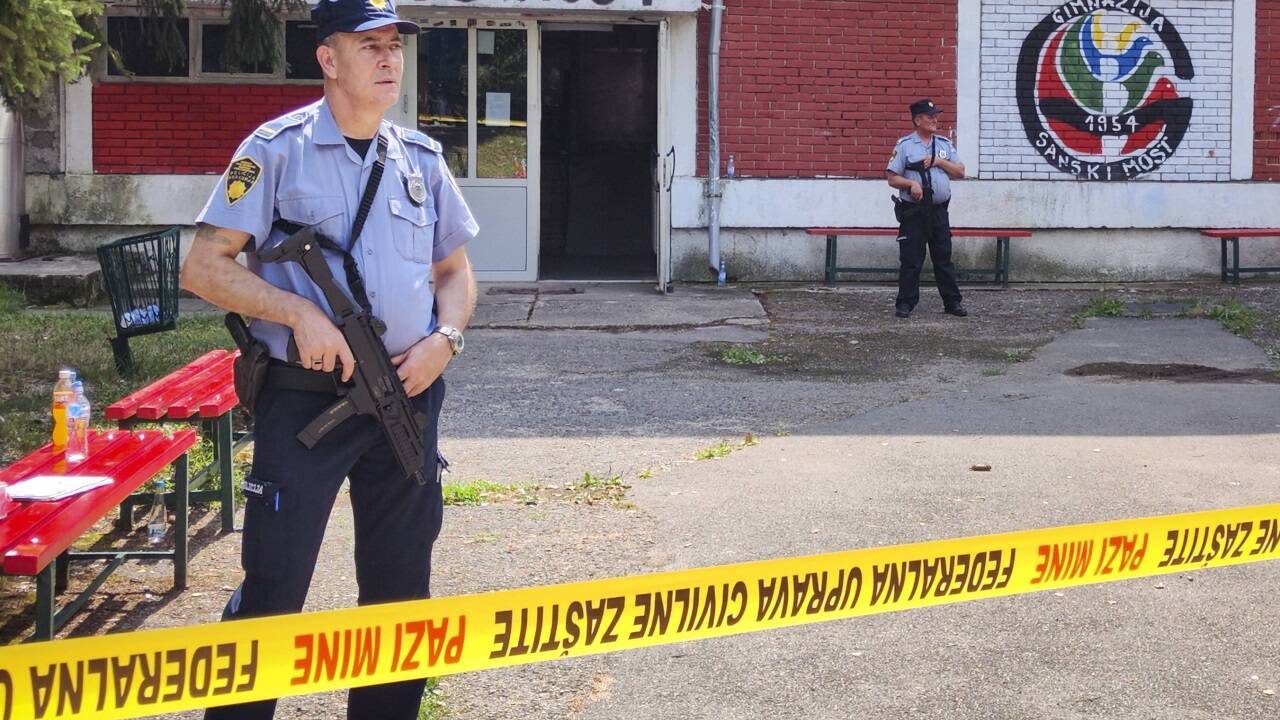 Polizisten stehen vor dem Gymnasium in Sanski Most, in dem die Schießerei stattgefunden hat.  Polizisten stehen vor dem Gymnasium in Sanski Most, in dem die Schießerei stattgefunden hat.