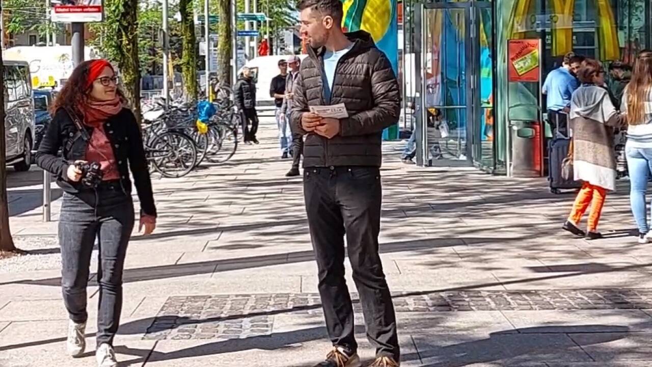 Tobias Schweiger von der KPÖ verteilte Flyer vor dem Salzburger Hauptbahnhof. 