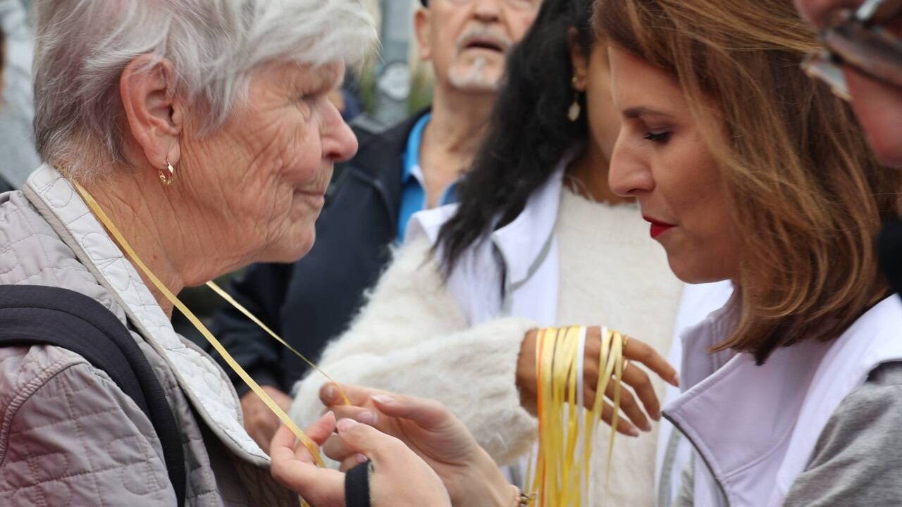 Ministerin Karoline Edtstadler hängt einer Schrannen-Besucherin ein Lebkuchenherz um. 