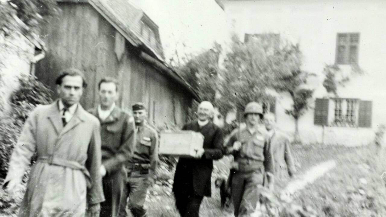 1945: US-Soldaten mit dem damaligen Mattseer Pfarrer Anton Strasser mit der Heiligen Hand. Die Kronlade war bis auf das Krönungsschwert leer – die Stephanskrone war noch am Unerseehügel vergraben.  