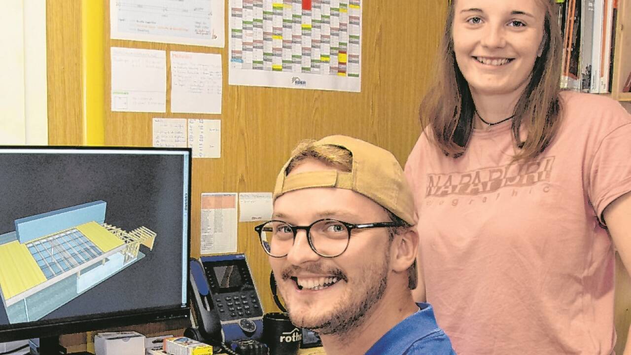 Sebastian Brandauer und Hannah Eder arbeiten am Computer an der Planung von Holzbauwerken wie einem Carport.  