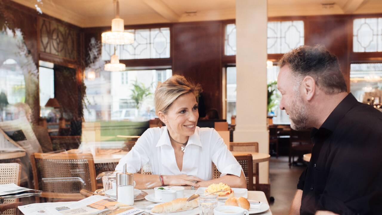 Gastgeberin Evelyn Brandstätter (im Bild mit Peter Gnaiger) in ihrem „Wohnzimmer“ namens Café Bazar. Hier gibt es seit Jahrzehnten Nahrung für Körper, Geist und Seele.  