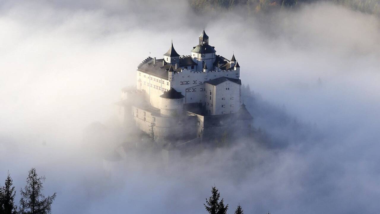 Die Burg Hohenwerfen, umringt von Nebel, erhöht auf dem Burghügel nördlich des Marktes in Werfen (Pongau).  