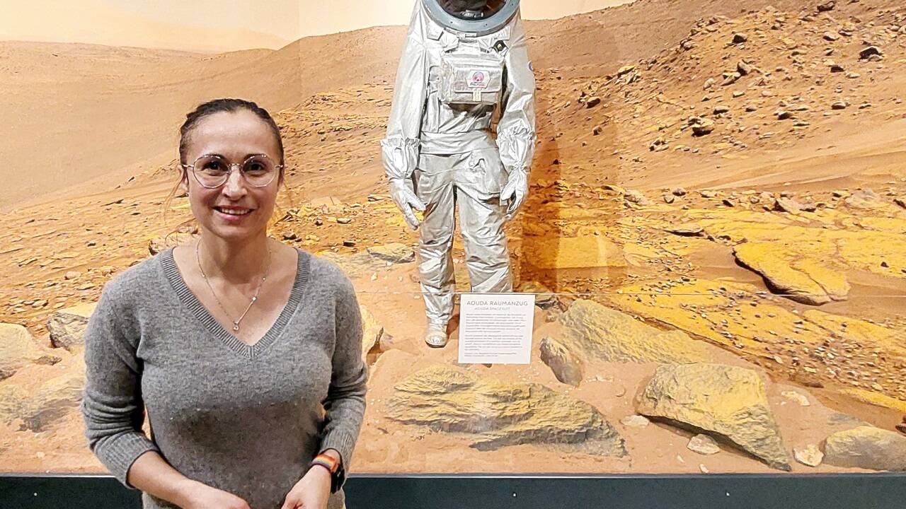 Julia Weratschnig, Astronomin am Haus der Natur, vor einem Schaubild der neuen Sonderausstellung „Mars – Die Entdeckung des Roten Planeten“. 
