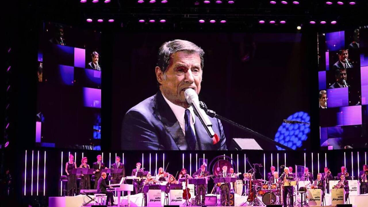 Udo sang vom Screen, die Band spielte Live 