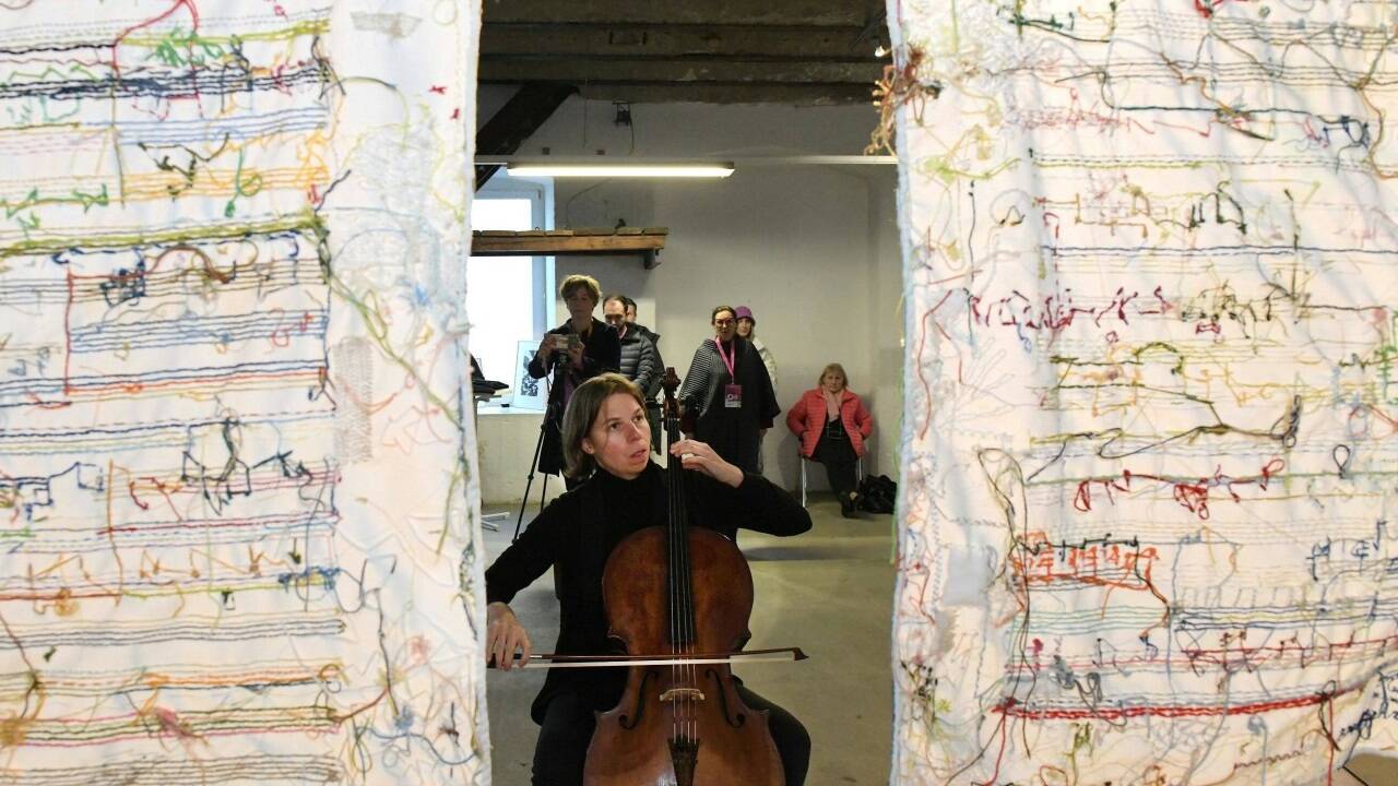 Cellistin Cecile Belmont mit textiler Partitur aus dem Projekt „Brucknersticken“ 