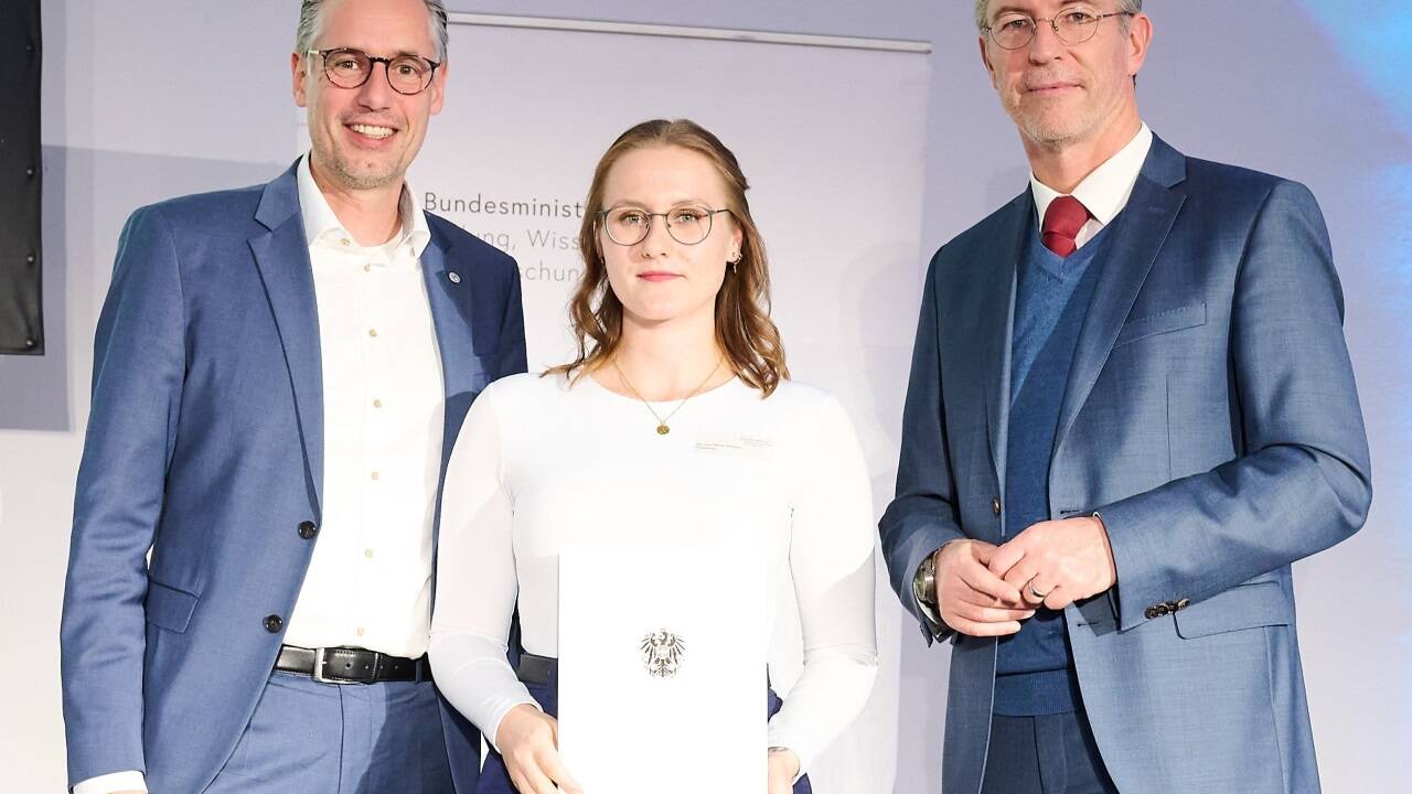 Preisträgerin Maren Gramitzky mit FH-Rektor Dominik Engel und Sektionschef Elmar Pichl bei der Übergabe des Staatspreises in Wien. 