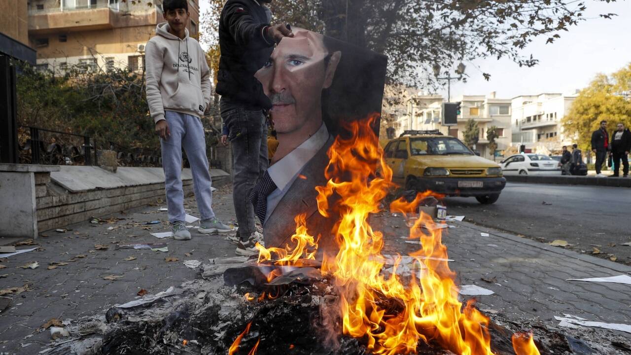 Ein Mann verbrennt in Damaskus ein Bild des ehemaligen syrischen Machthabers Assad. Ein Mann verbrennt in Damaskus ein Bild des ehemaligen syrischen Machthabers Assad.