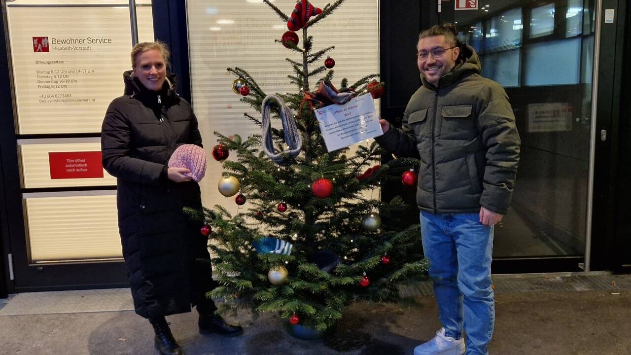 Simone Engler und Ismail Burak Aydogan beim „Pflück dir Wärme“-Baum des Bewohnerservice in der Elisabeth-Vorstadt. 