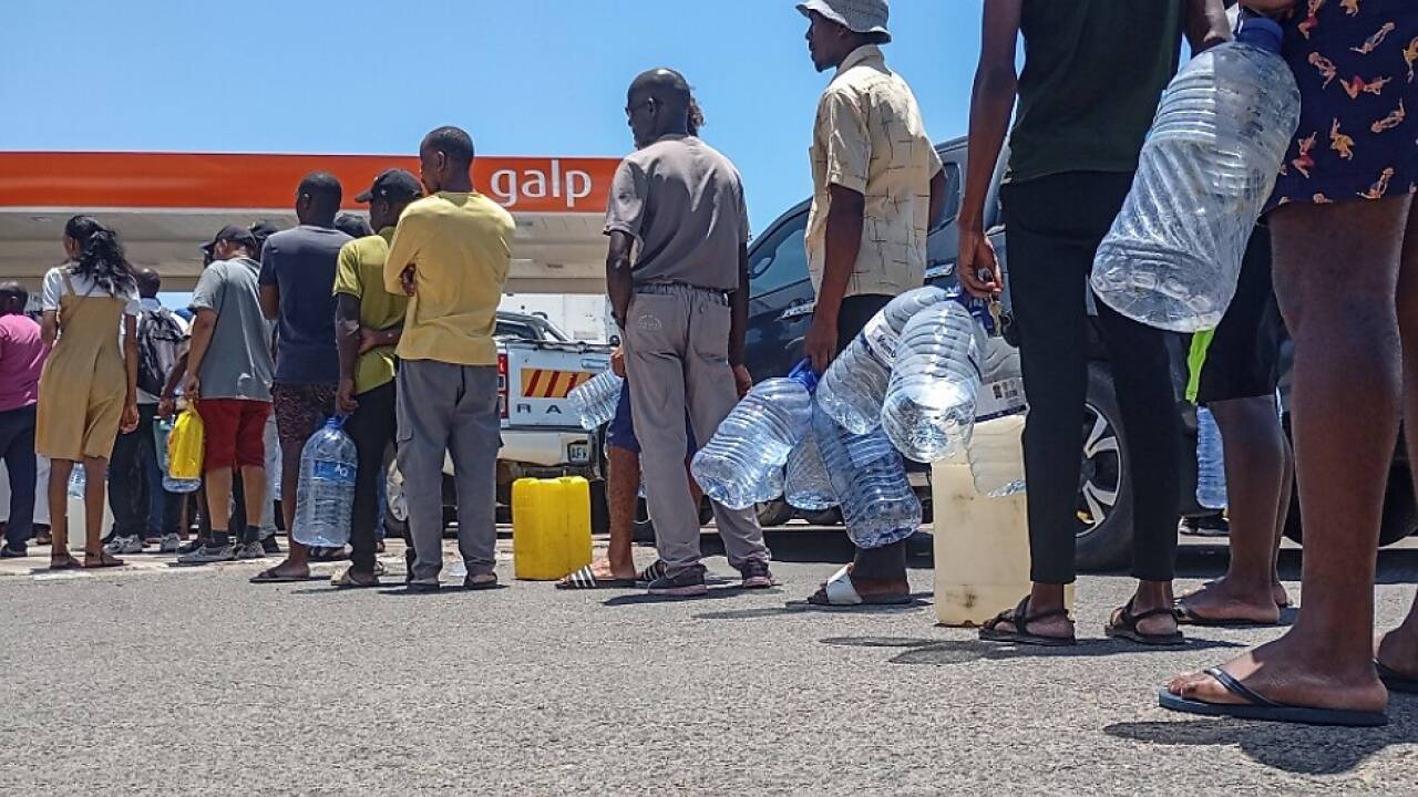 Menschen stehen an einer Tankstelle an  Menschen stehen an einer Tankstelle an