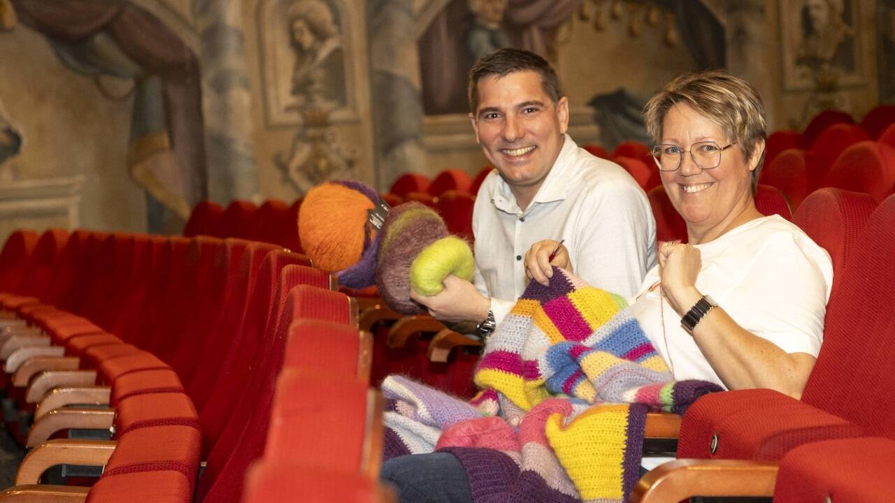 Geschäftsführer Alexander Krammer vom Mozartkino und Altstadtunternehmerin Maria Felber vom Wollzimmer mit einer Häkeljacke.  