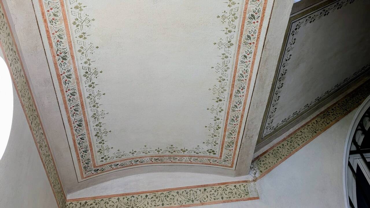 Deckenmalerei im Stiegenhaus im Pfarrhaus St. Andrä mit Kirschlorbeer und geometrischen Formen. 
