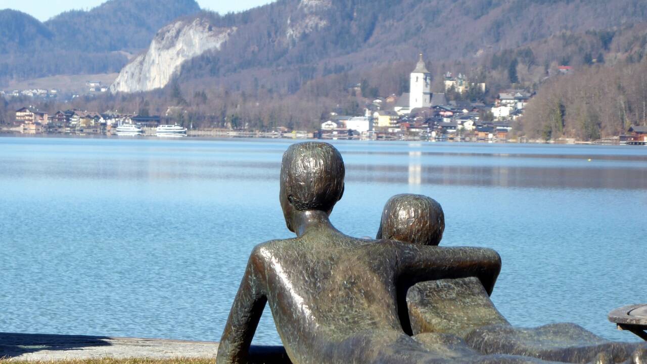 Das „Platonische Liebespaar“ von Eva Maria Mazzucco träumt auf der Uferpromenade in Strobl von St. Wolfgang.  