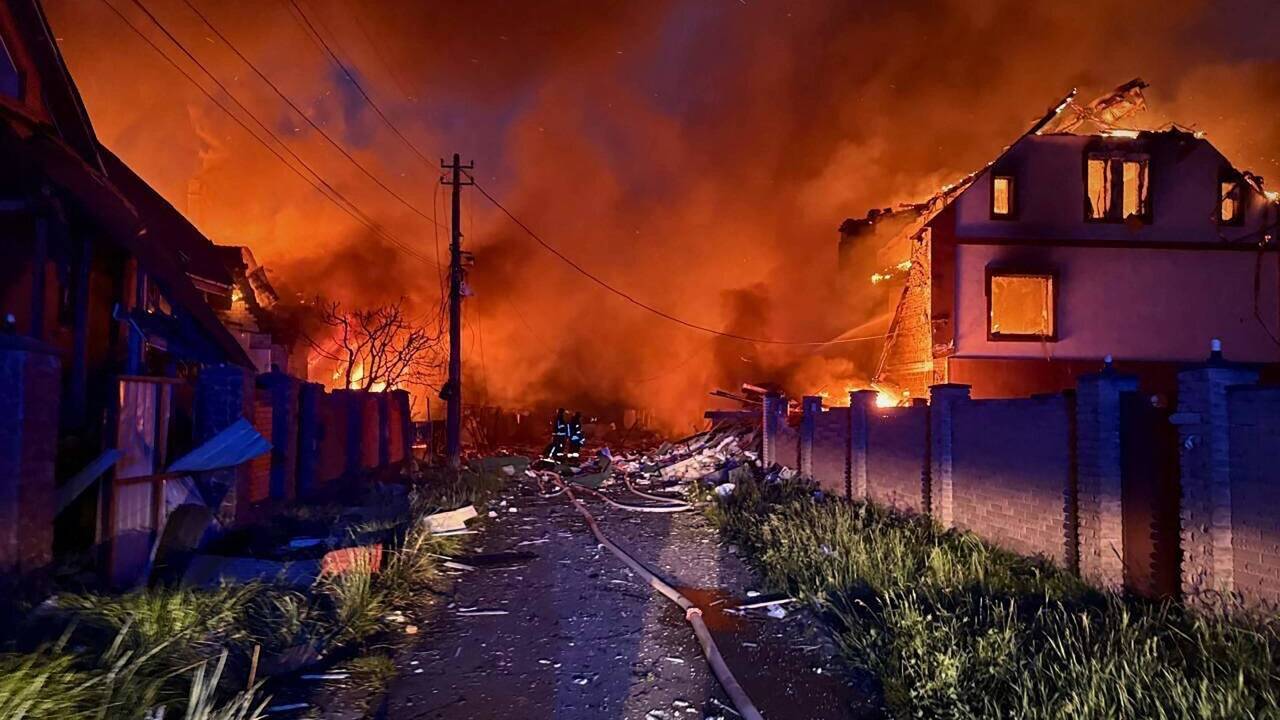 Blutroter Feuerschein über den Ruinen, verkohlte Bäume, verbogene Zäune.   Blutroter Feuerschein über den Ruinen, verkohlte Bäume, verbogene Zäune.