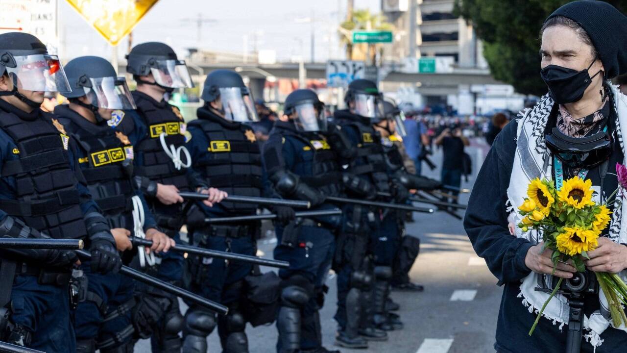 Blumen statt Gewalt: Eine Demonstrantin setzt ein Zeichen für friedlichen Protest. Blumen statt Gewalt: Eine Demonstrantin setzt ein Zeichen für friedlichen Protest.