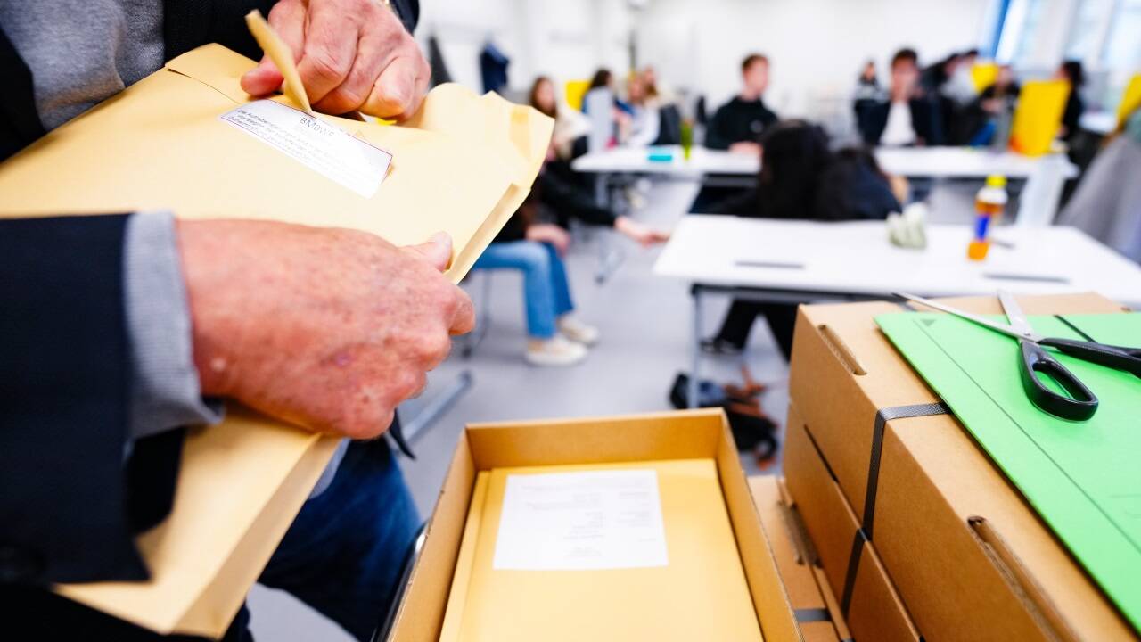 Lehrer öffnet versiegelte Kartons mit den Maturafragen (Symbolbild). 