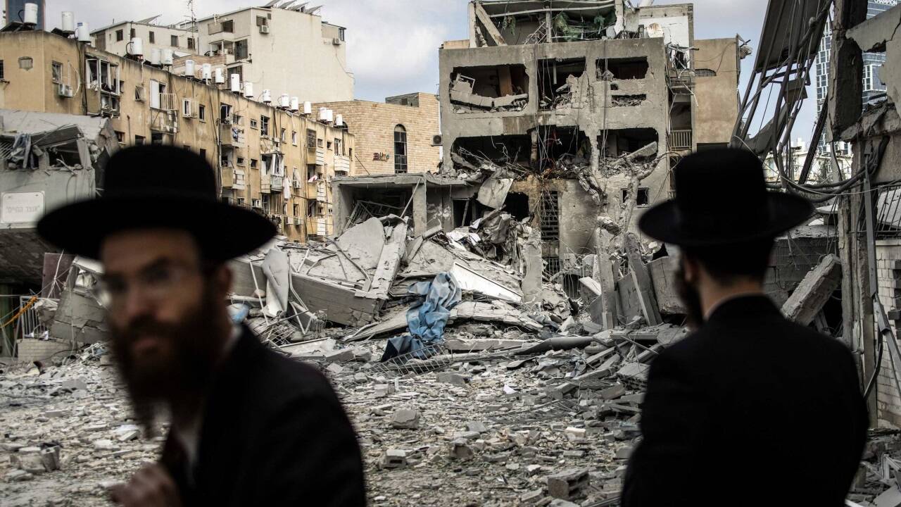 Ultra-Orthodoxe Juden vor den Ruinen eines iranischen Raketenangriffs in Tel Aviv. 