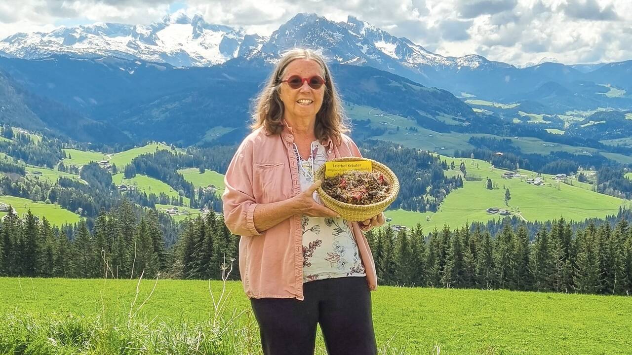 Renée Schroeder in ihrem grünen Reich hoch über Abtenau – vor der traumhaften Kulisse des Dachsteins. 