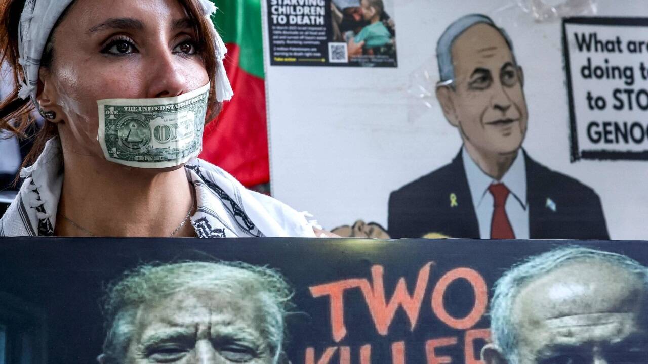 Eine Protestierende hat sich einen Dollar-Schein über den Mund geklebt. 