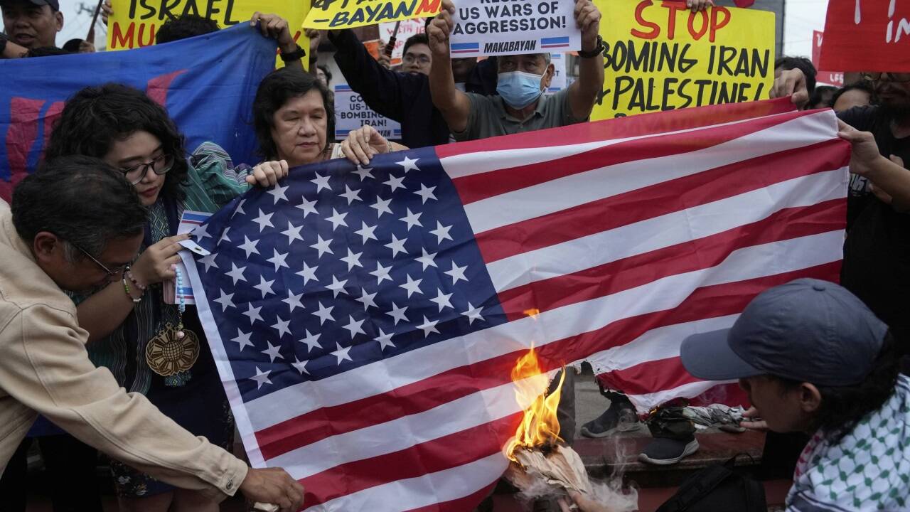Protestierende verbrennen die US-Flagge nach den Angriffen auf den Iran. Protestierende verbrennen die US-Flagge nach den Angriffen auf den Iran.