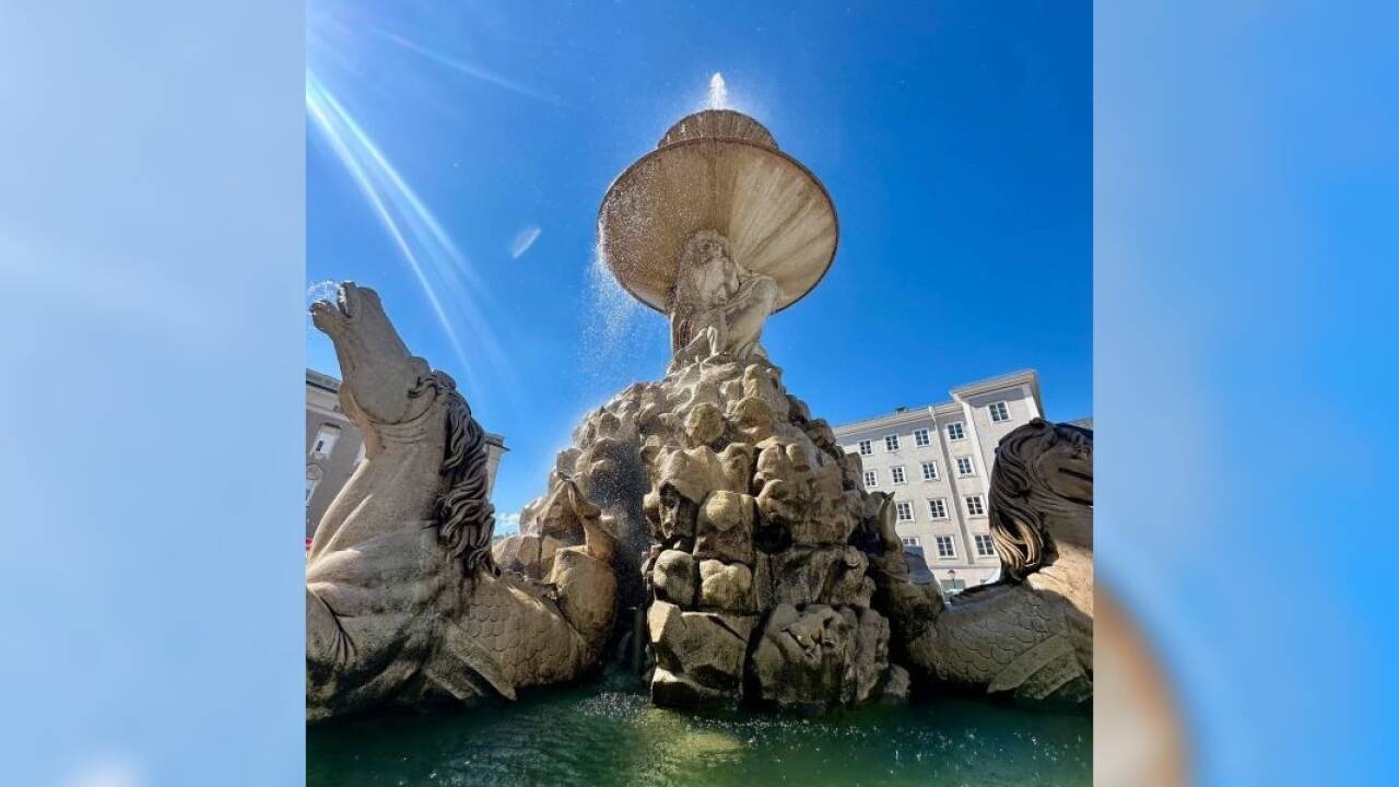 Am Residenzbrunnen spendet ein feiner Sprühregen Abkühlung.  