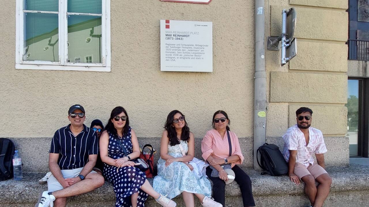 Touristen aus Indien und den USA suchten am Nachmittag Abkühlung auf der Steinbank neben den Festspielhäusern.  