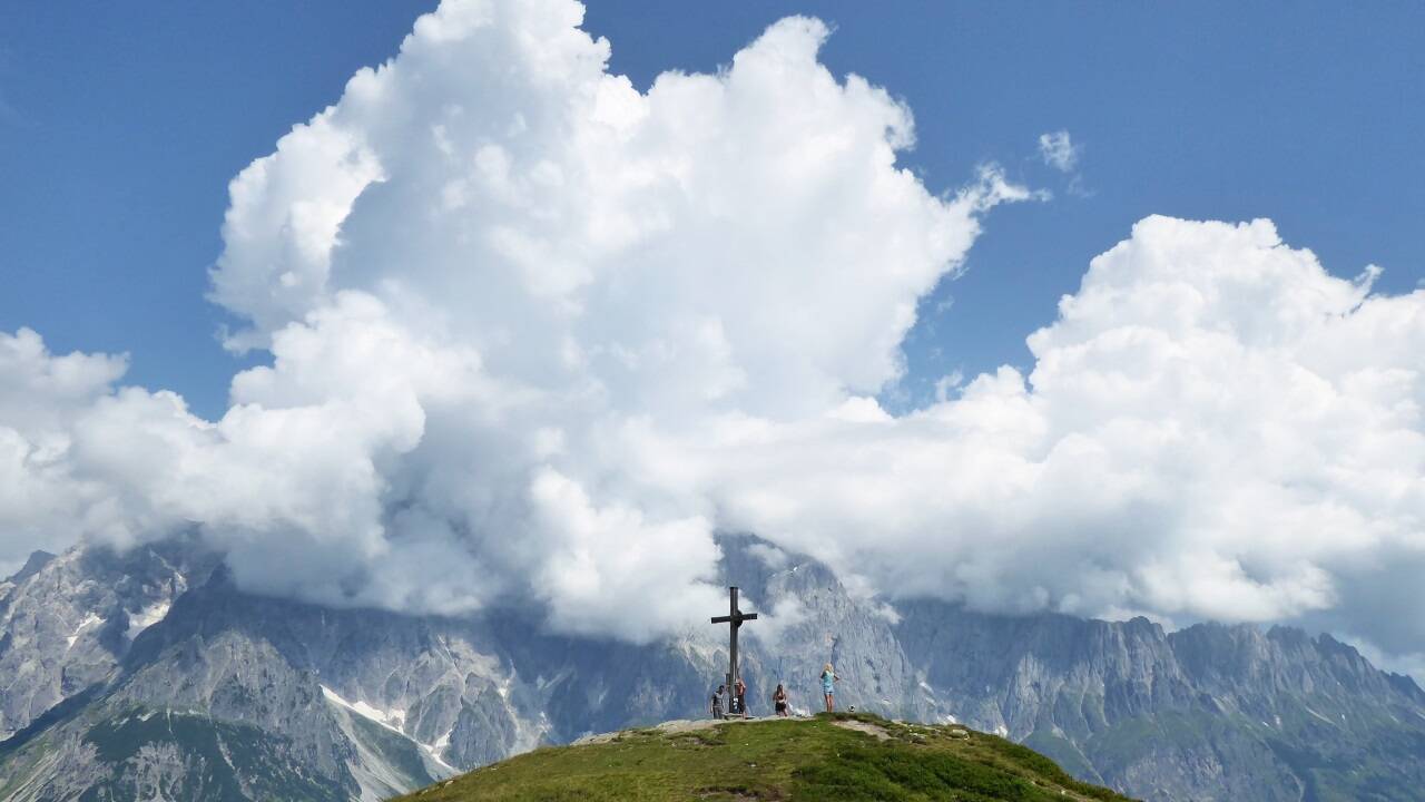 Das Schneebergkreuz vor dem wolkenverhangenen Hochkönig.  