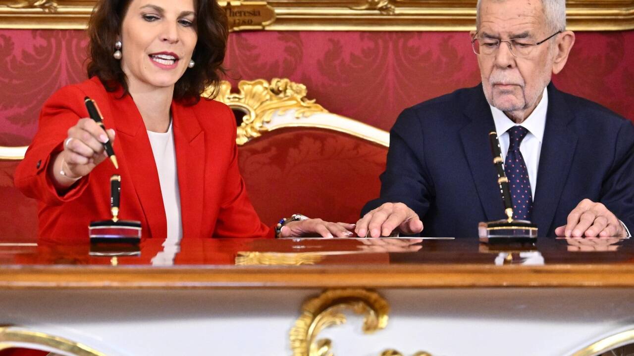 Edtstadler beim Unterschreiben mit dem Bundespräsidenten.  