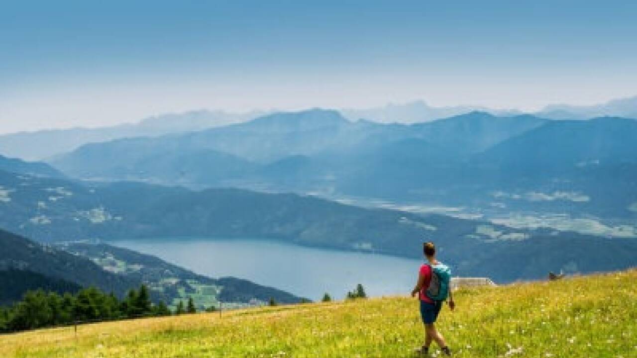 Wandern über die sommerlichen Wiesen der Millstätter Alpe: Im Tal glitzert verführerisch der Millstätter See.  