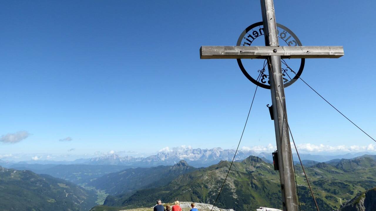Zufriedene Rast unter dem Gipfelkreuz der Glöcknerin.  