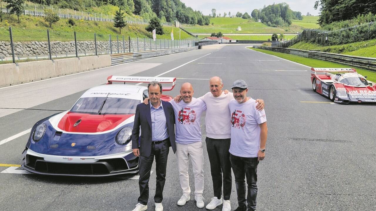 Robert und Walter Lechner mit den langjährigen Wegbegleitern Walter Schöch (l.) und Franz Tost sowie einem Rennboliden von früher (hinten) und dem im Porsche Supercup verwendeten 911er GT3 Cup. 
