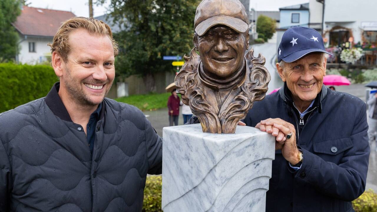 Niki Laudas Sohn Lukas und die deutsche Rennfahrerlegende Hans-Joachim Stuck freuen sich über die Enthüllung der Büste.  